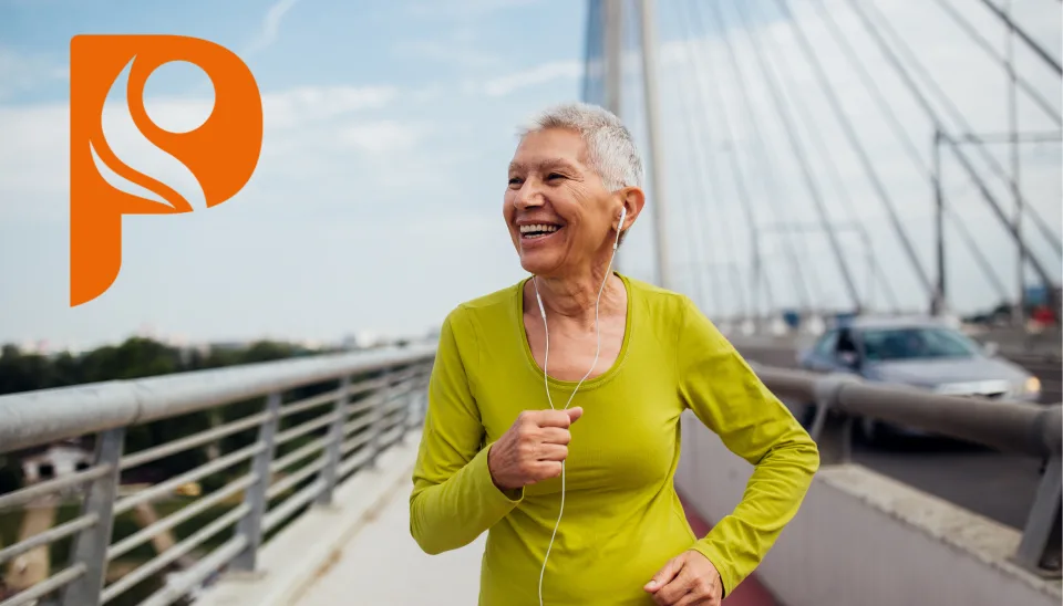 Ältere Frau joggt gut gelaunt über eine Brücke
